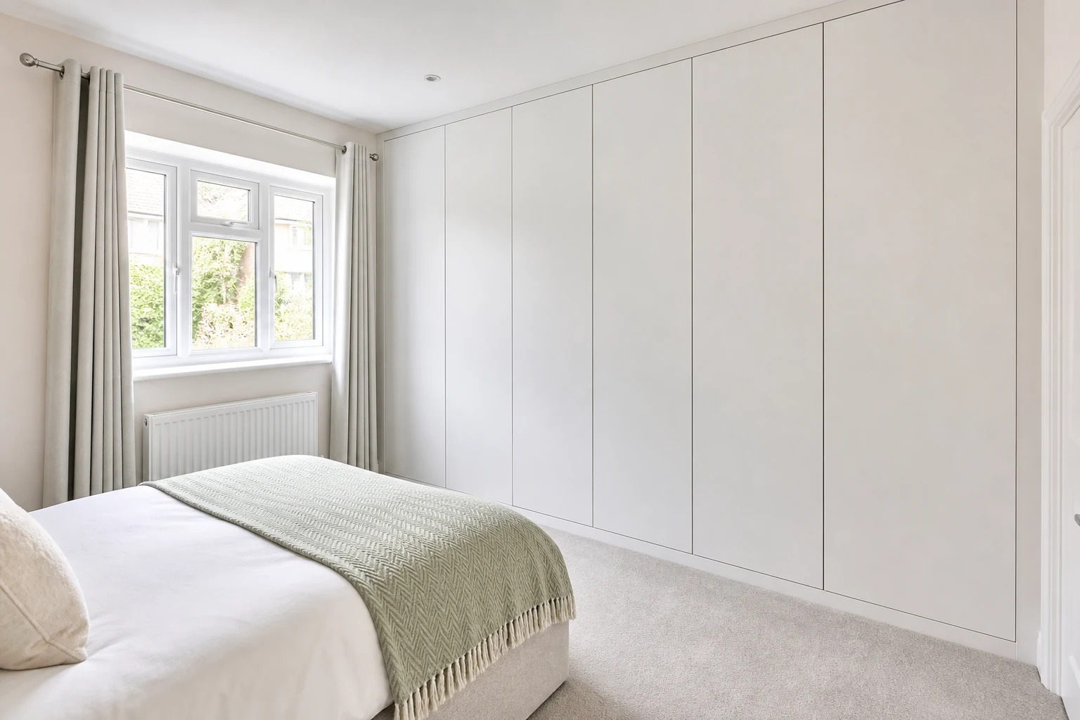 Small bedroom with fitted wardrobes and less freestanding furniture
