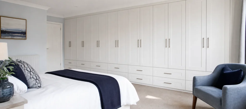 Small bedroom with white fitted wardrobes and a tidy uncluttered layout